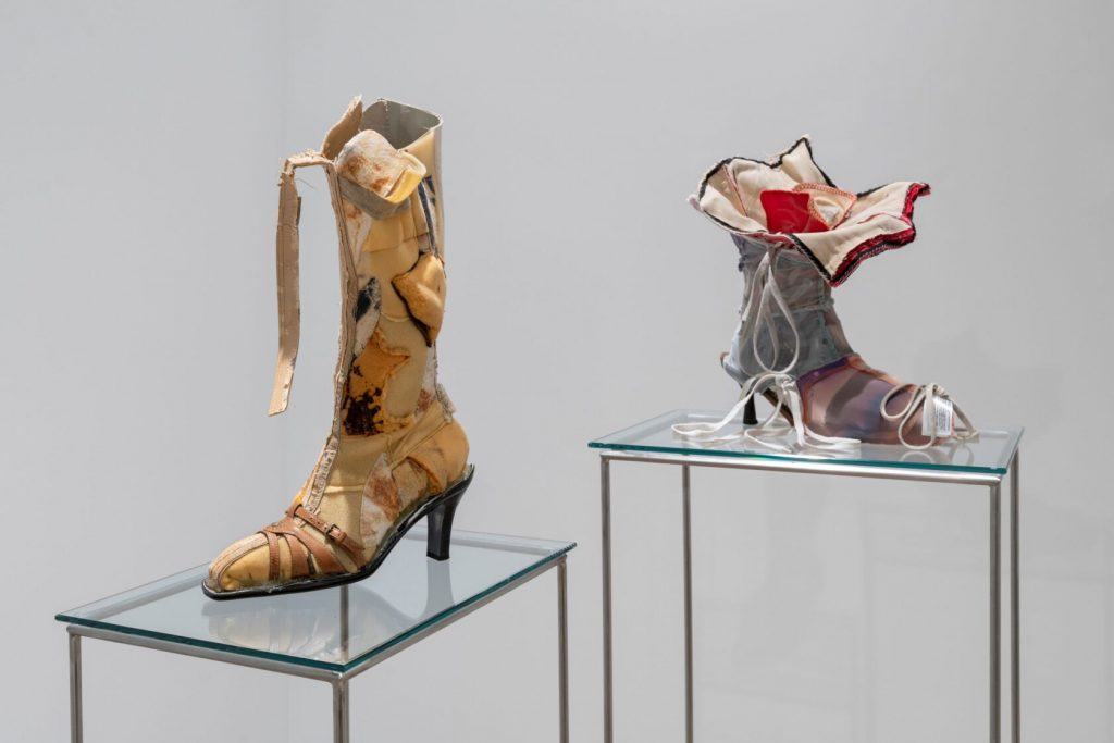 Two single shoes in a small heel style and colours of yellow, red, white, black and grey.